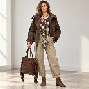 Modelo de moda com mala e colar.webp