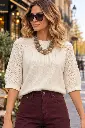 Blusa de malha bege num café parisiense.webp