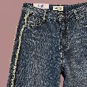 Detalhe de jeans azul-escuro em fundo rosa-1.webp